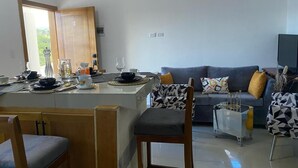 Una sala moderna con un sofá, sillones y una mesa de centro.