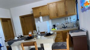 Una cocina con armarios de madera, una isla central con asientos y una estufa.
