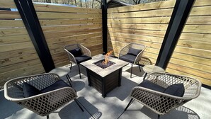 An outdoor patio with a fire pit table surrounded by wicker chairs with cushions. -  The "Stable" at OGR!  5 Star Accommodations! 
Resort pool and spa!  Sleeps 4 (Holland)