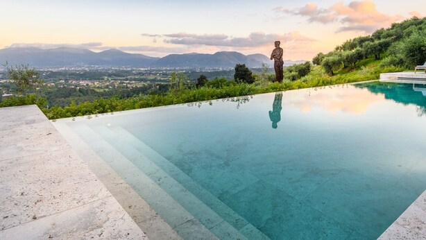 On aperçoit clairement une piscine, avec un paysage montagneux en arrière-plan.