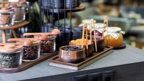 A buffet setup with various food items and utensils on trays.