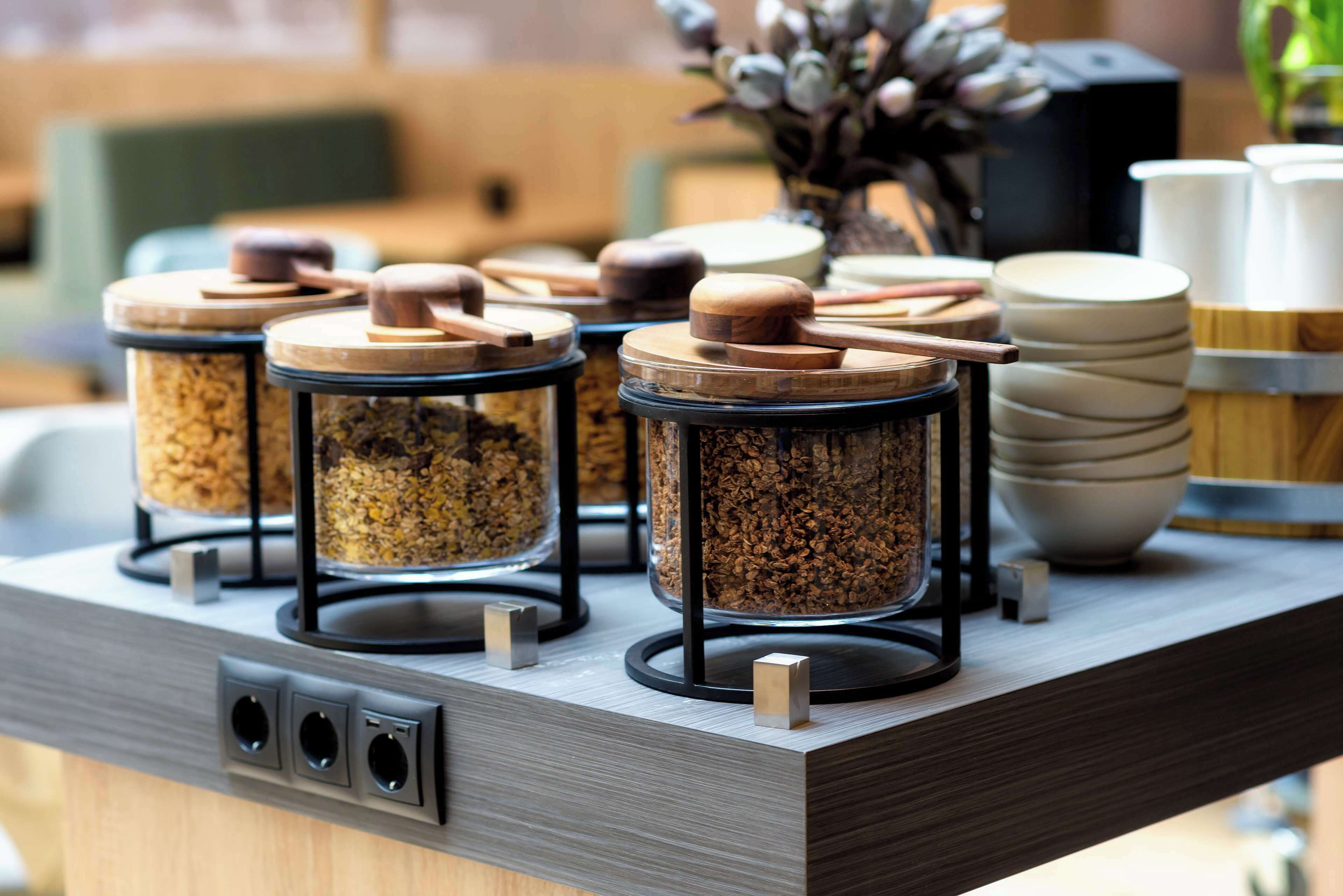 A kitchen counter with multiple spice jars, a coffee machine, and stacked bowls.