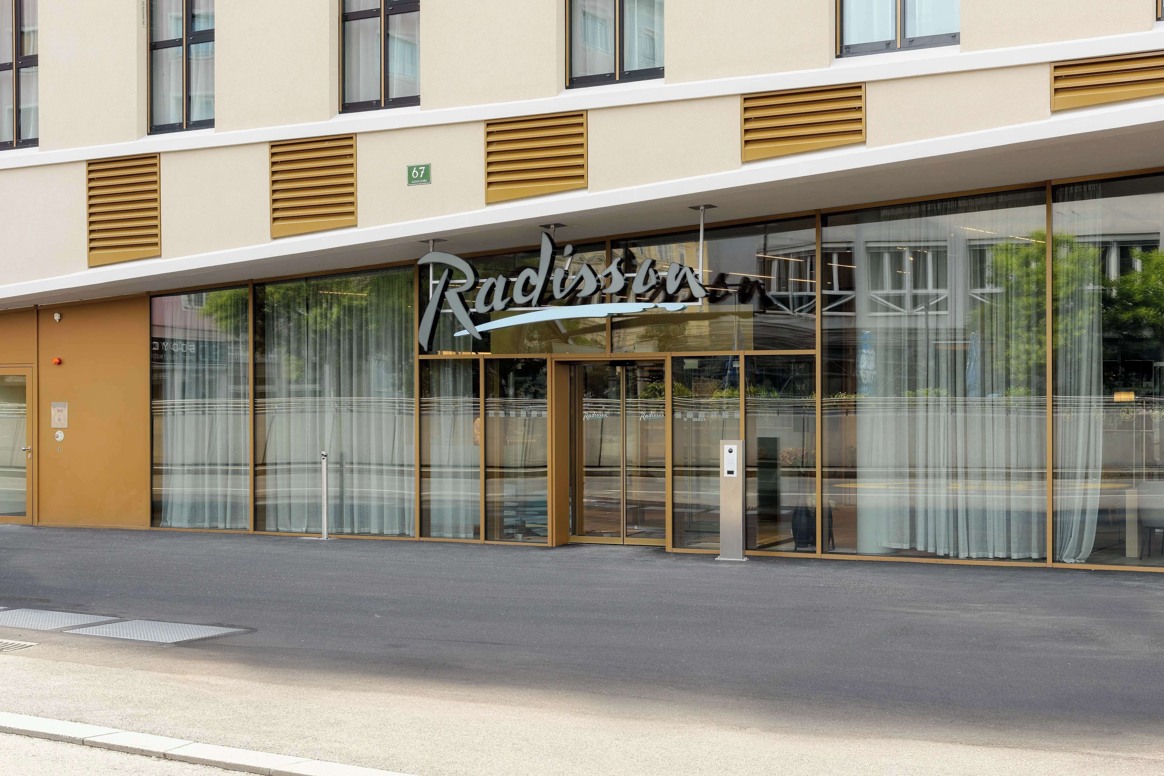 A hotel with a modern facade, large glass windows, and a prominent signage.