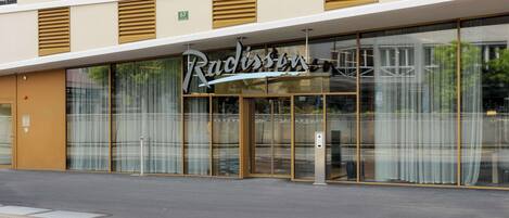 A hotel with a modern facade, large glass windows, and a prominent signage.