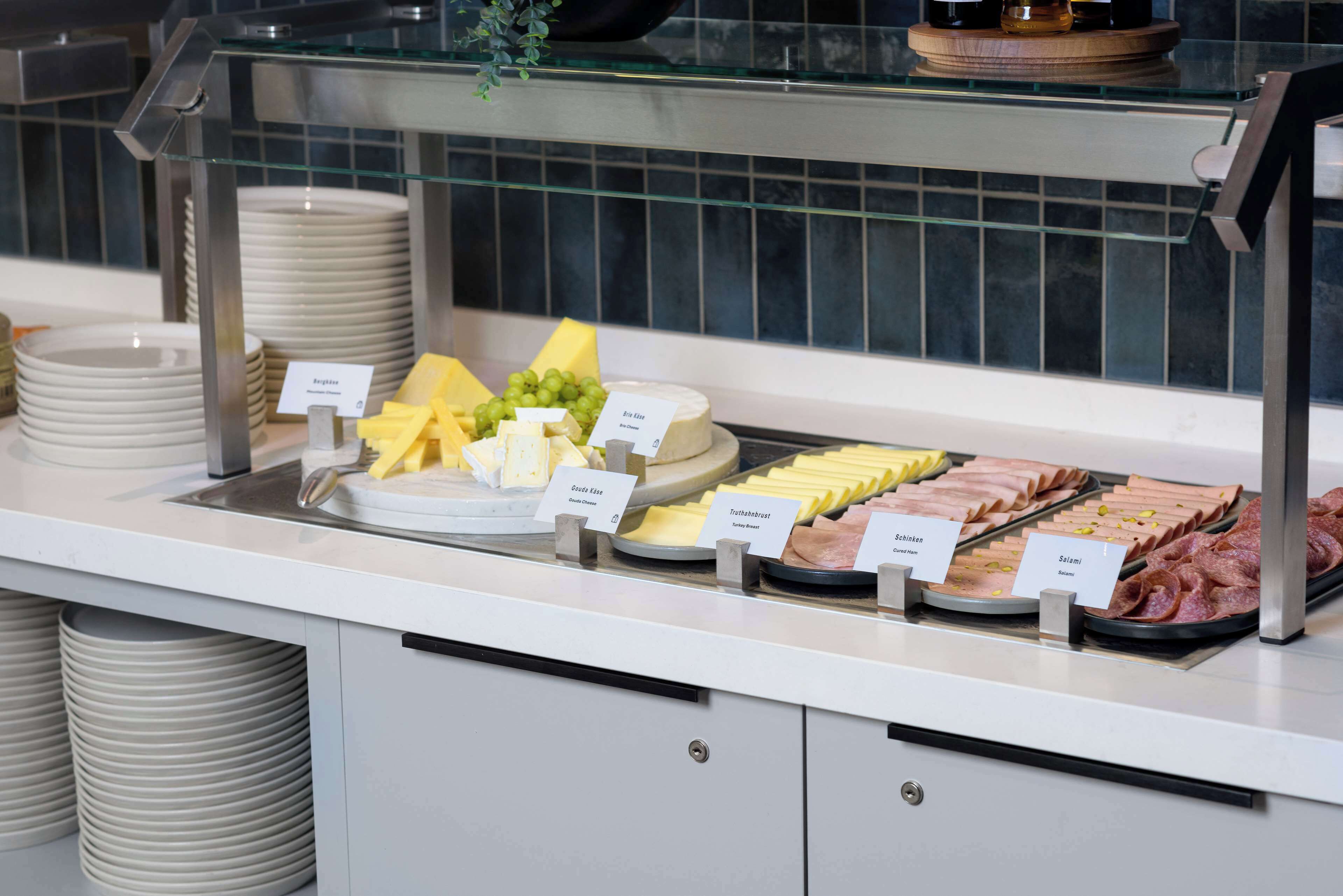 A buffet with various food items including cheese, ham, and sliced meats.
