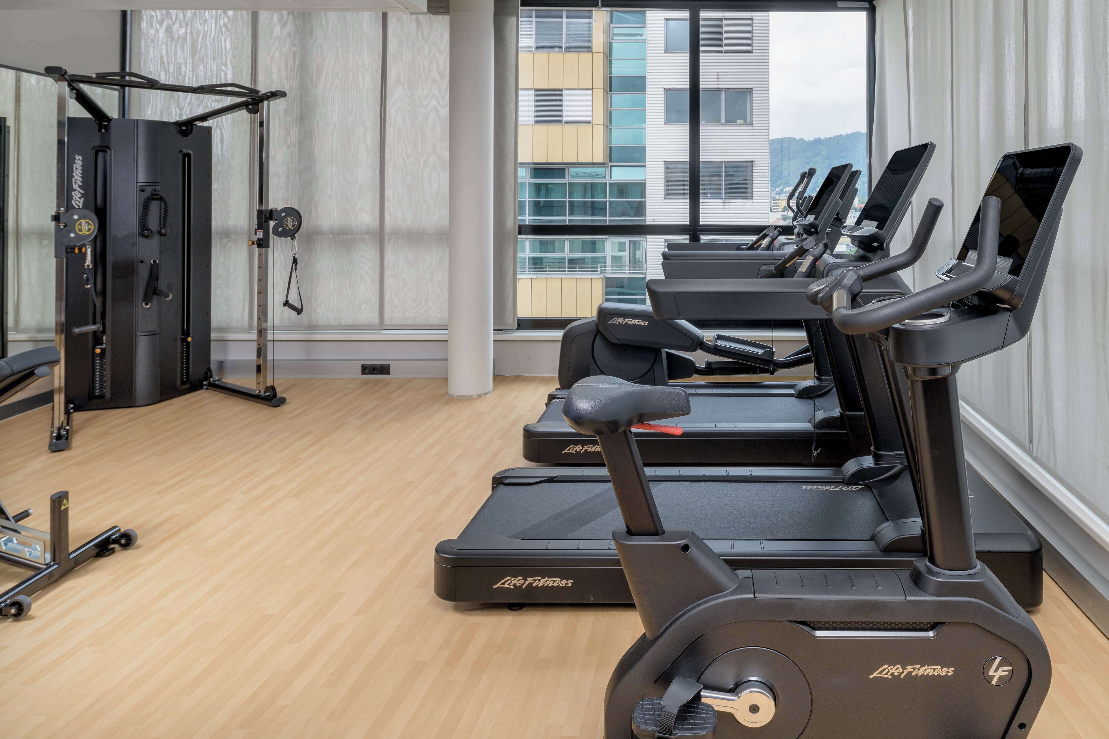 A gym with treadmills, a weight machine, and a pull-up bar.