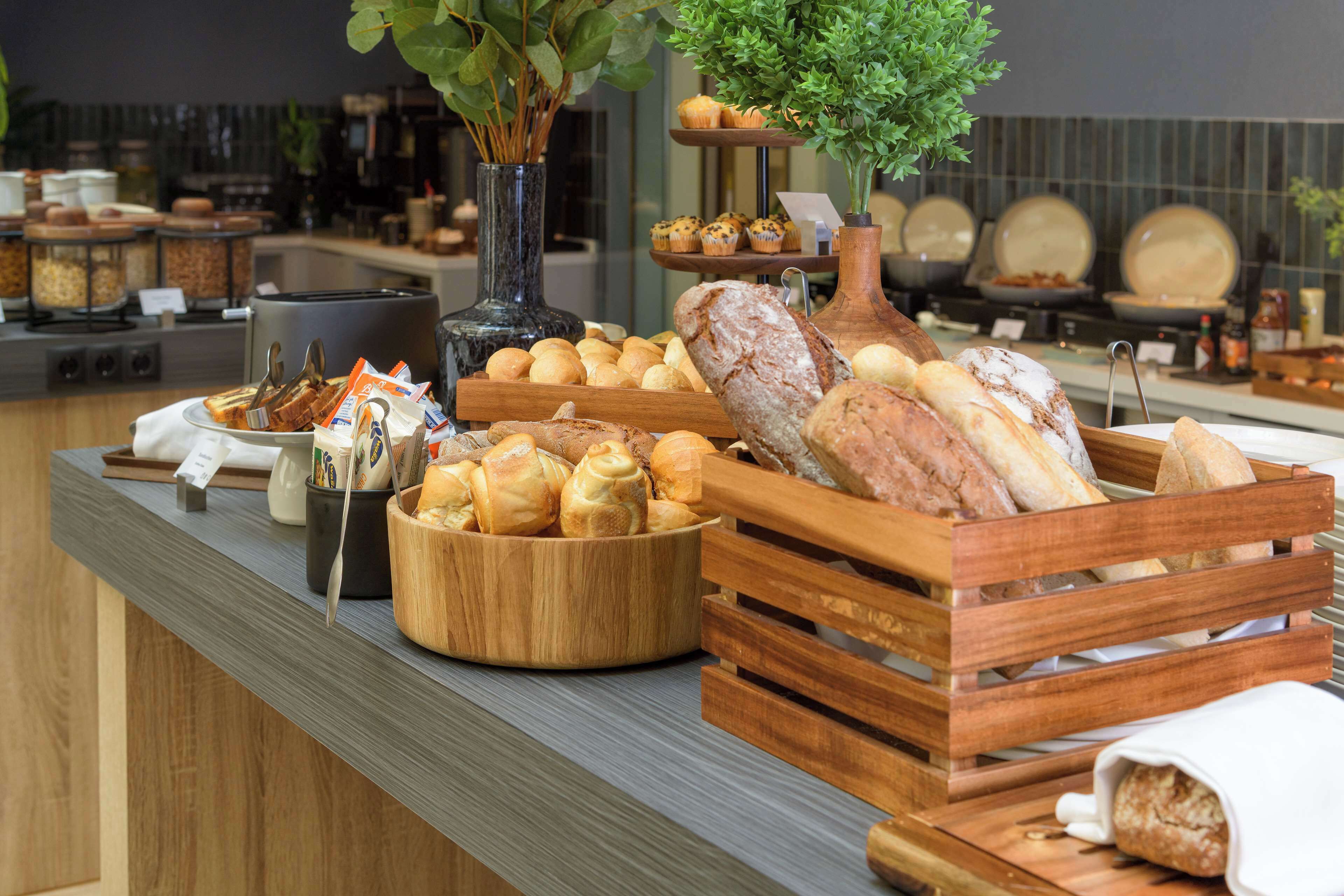 A buffet with various breads, pastries, and a coffee station.