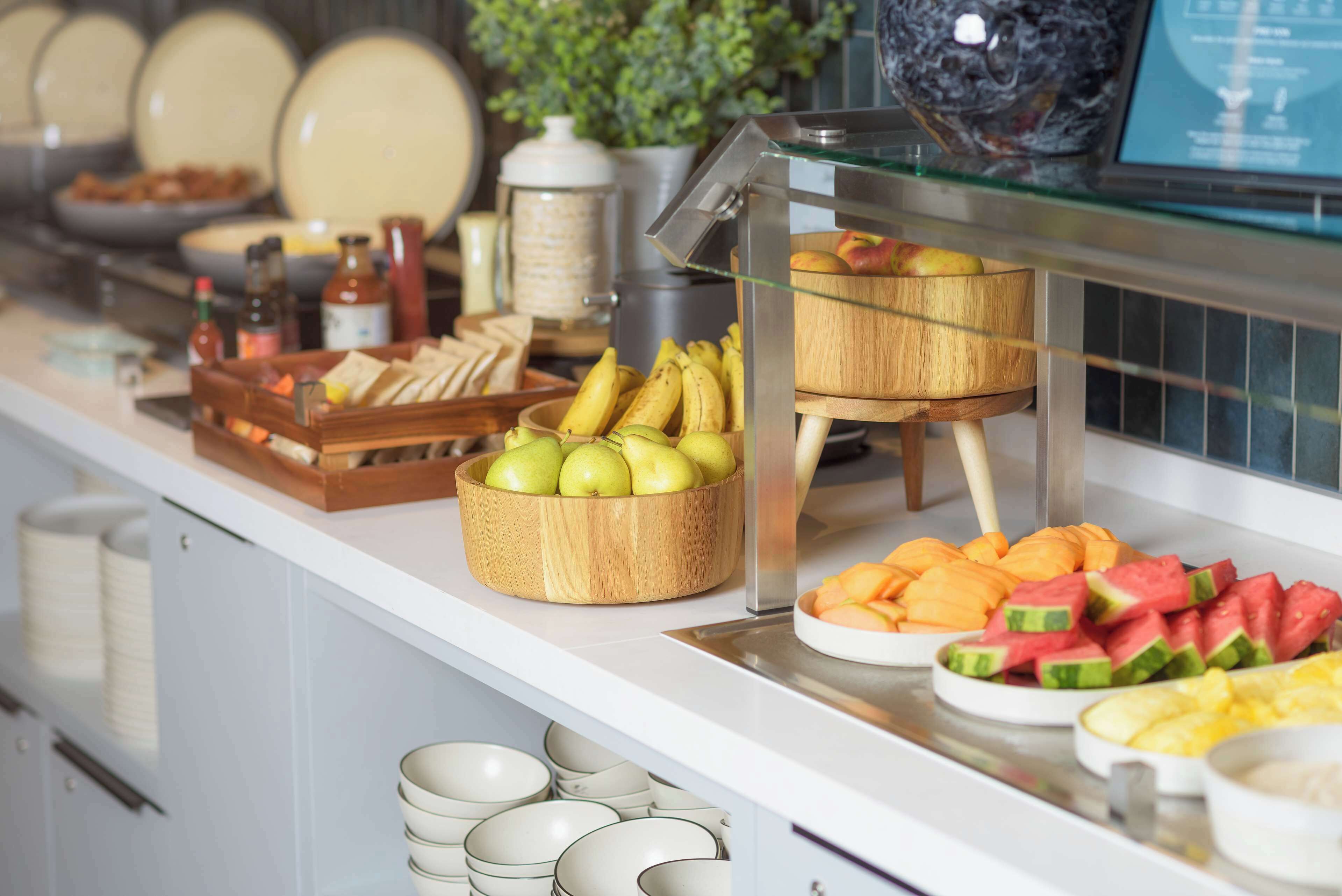 A buffet with various fruits and condiments.
