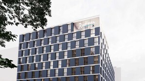 A modern hotel with a dark facade and a prominent Radisson logo. - Radisson Hotel Graz (Graz)