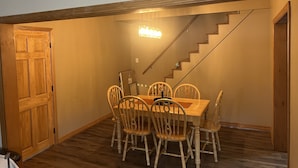 A dining area with a wooden table and chairs, a staircase, and a wooden door. - Newly renovated, only 2 miles from downtown Fort Kent.  Right across from trails (Fort Kent)