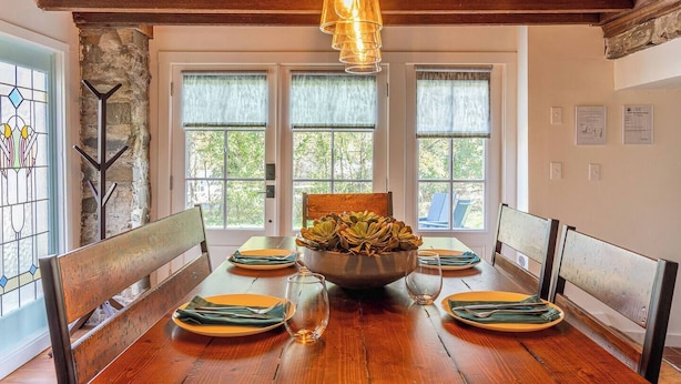 A dining room with a wooden table, chairs, and a central bowl of fruit. - Spacious 4BD Country Gem - Fire Pit & Chill Vibes (Highland)