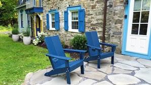 Two Adirondack chairs outside a stone building with a blue door and shutters. - Spacious 4BD Country Gem - Fire Pit & Chill Vibes (Highland)