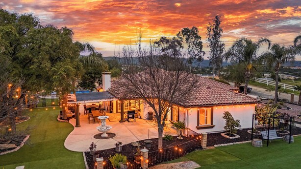 A house with a patio, outdoor seating, and a well-maintained lawn. - Breathtaking Meadows by Avantstay Temecula Group Retreat Pool, Pickleball, Firepit, Hot Tub (Temecula)