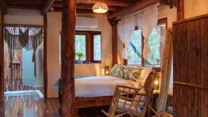Une chambre à coucher avec un cadre en bois, comprenant un lit, un fauteuil à bascule et une fenêtre avec des rideaux.