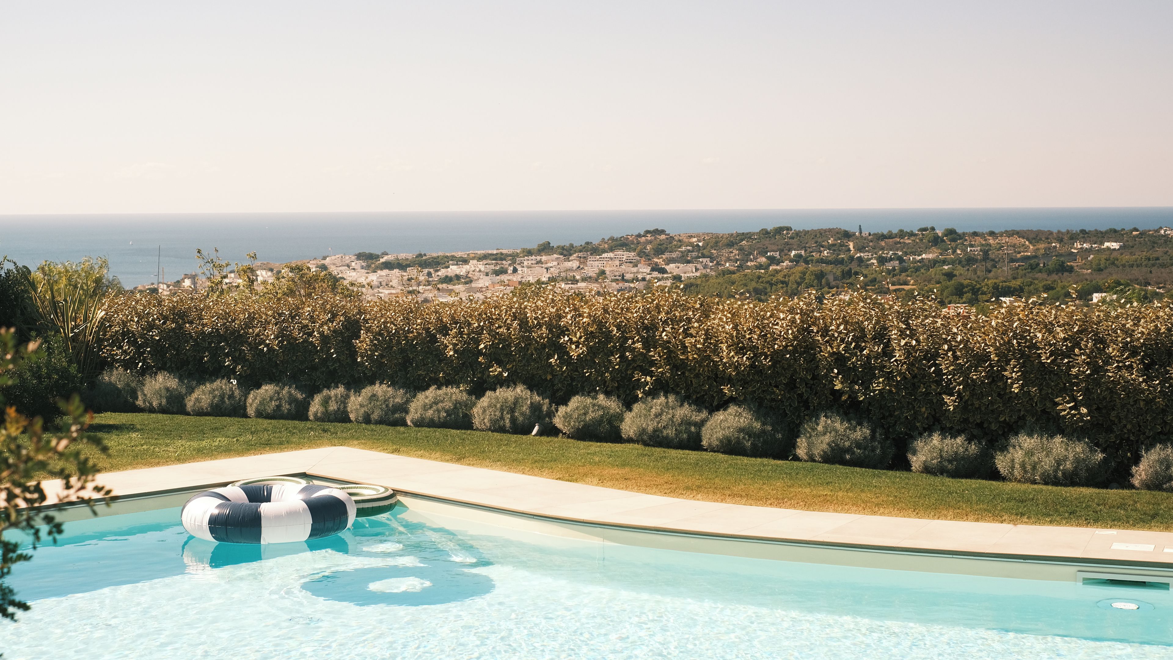 Una piscina con vistas al mar y un jardín ajardinado.