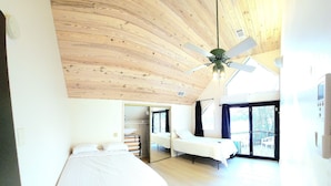 A room with two beds, a ceiling fan, and a large window. - White River Lodge #3 (Lakeview)