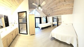 Un dormitorio con cama, vestidor y baño con ducha.