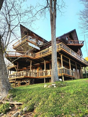Una cabaña de madera de varios pisos con balcones y un letrero que dice "NEWLANDS".