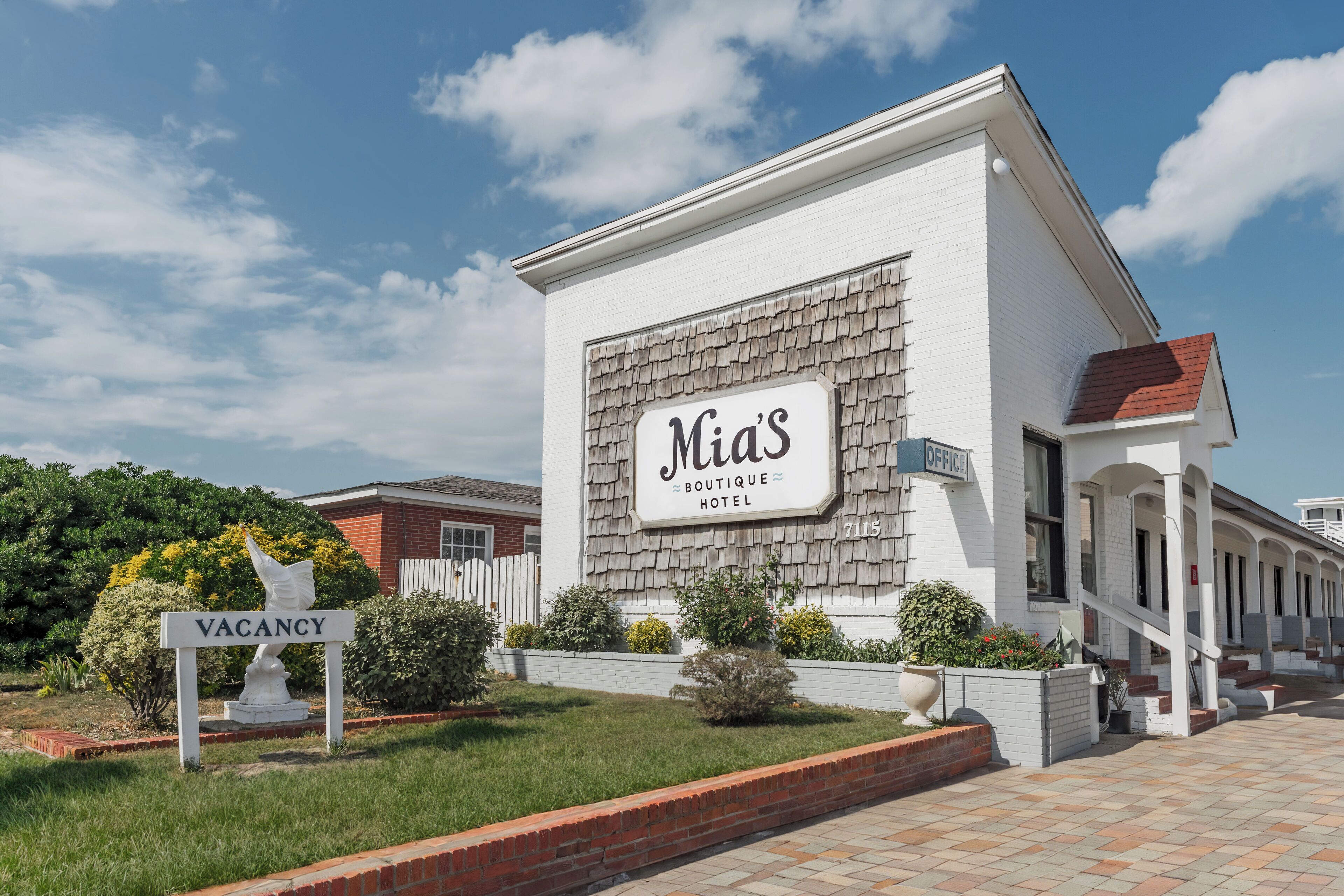 A building with a sign reading "Mia's Boutique Hotel" and a "VACANCY" sign in front.