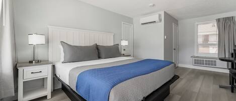 A modern bedroom with a bed, bedside tables, and a window.