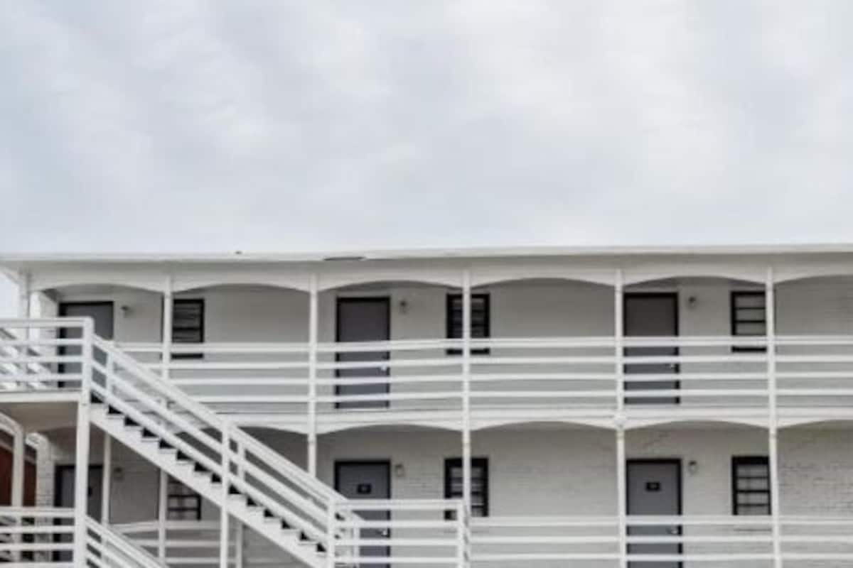 A multi-story building with a white exterior and a central staircase.