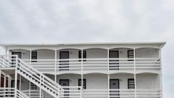 A multi-story building with a white exterior and a central staircase.