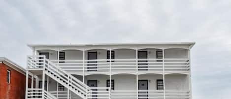 A multi-story building with a white exterior and a central staircase.