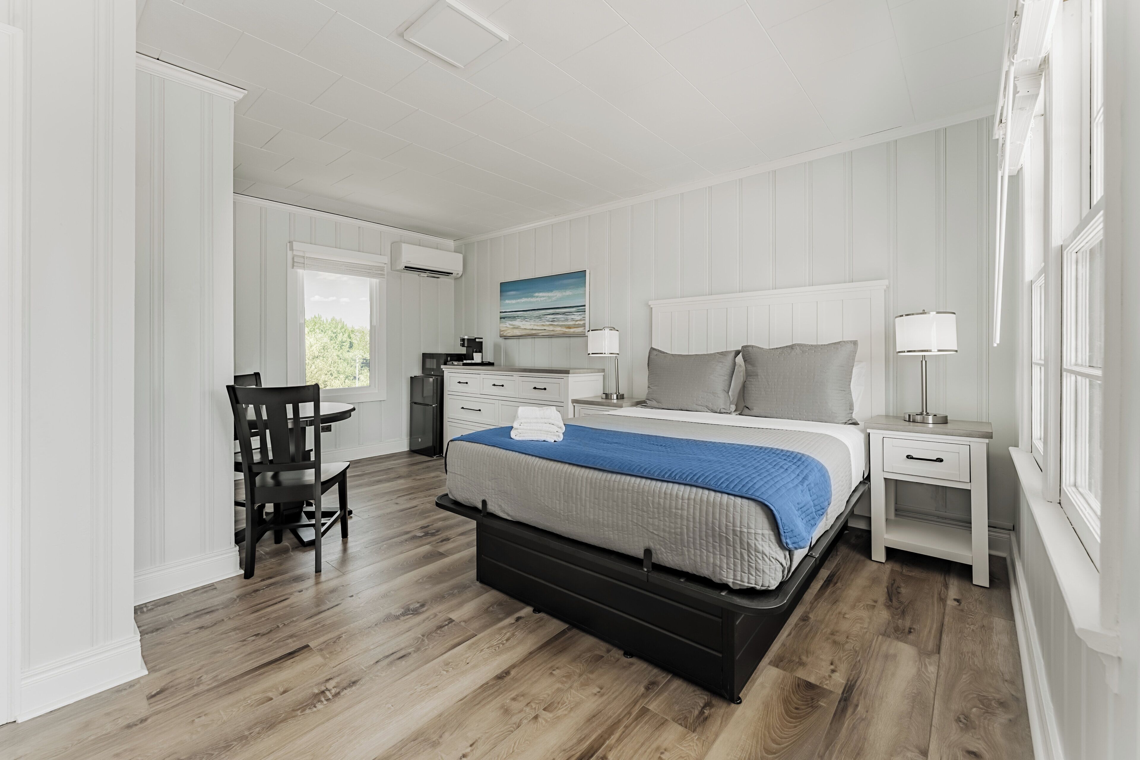 Une chambre à coucher avec un lit, des tables de chevet, un bureau et une chaise.