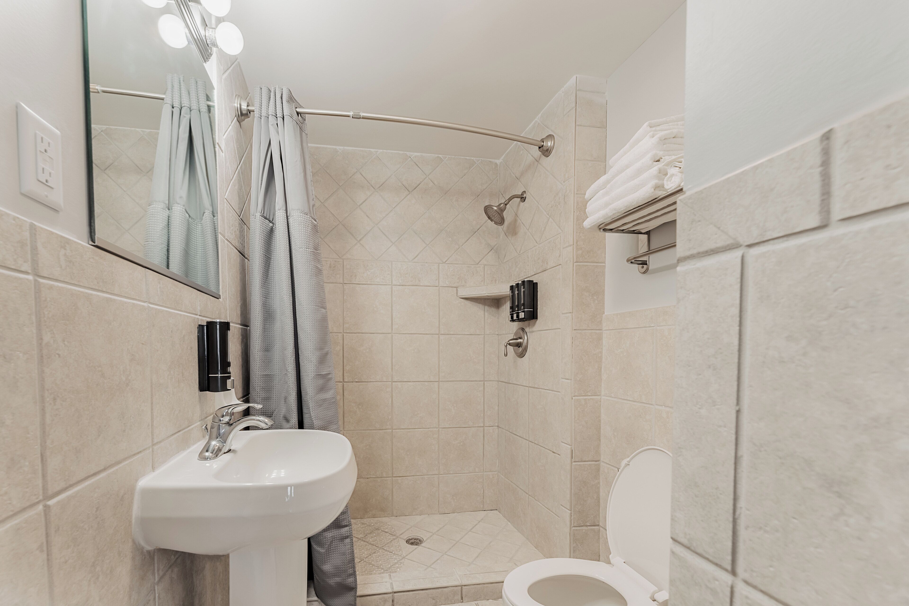 Uma casa de banho moderna com lavatório, sanita e chuveiro.