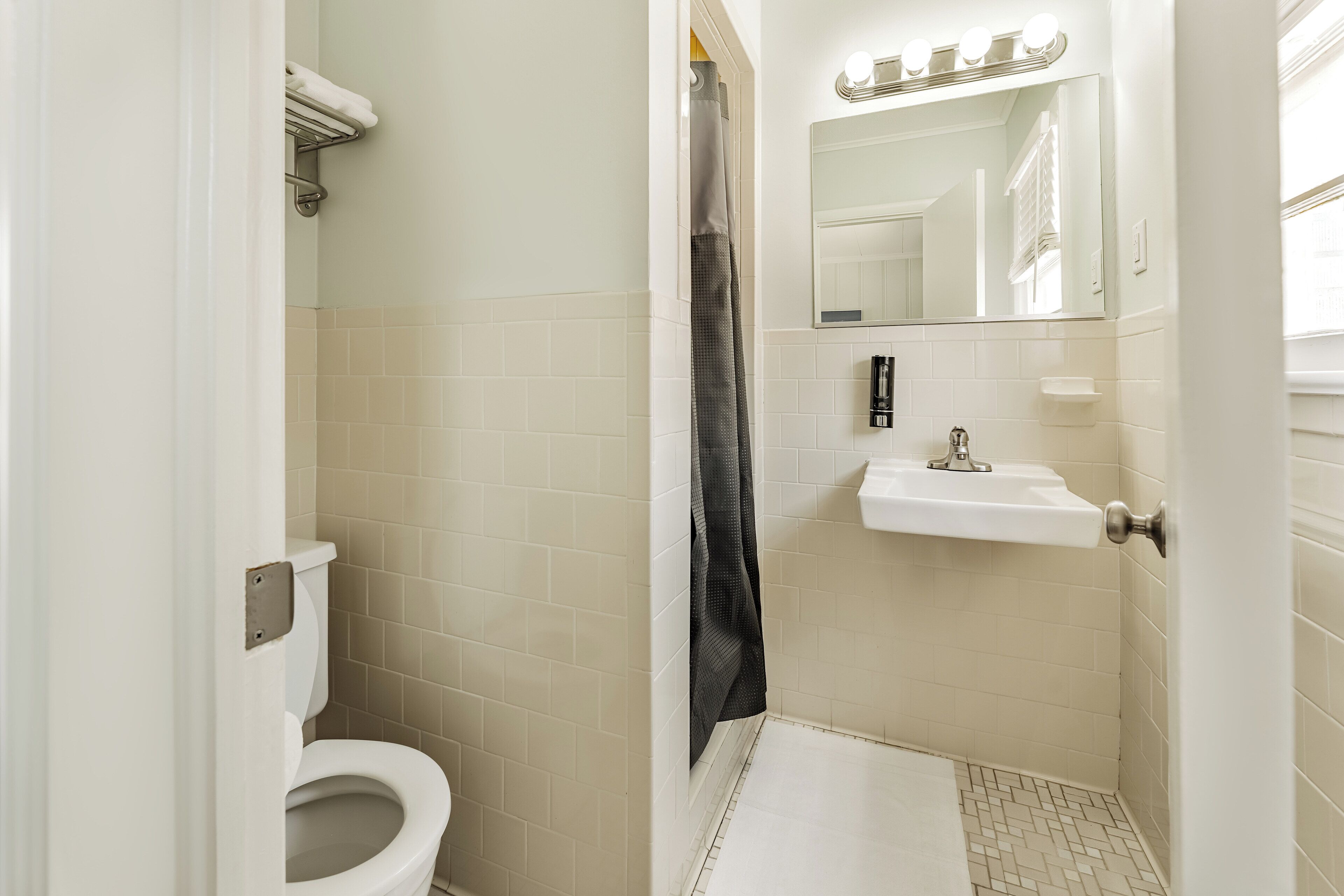 Een badkamer met toilet, wastafel en douchegordijn.