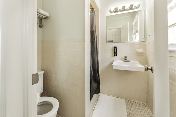 Un baño con inodoro, lavabo y cortina de ducha.