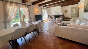 Un'ampia zona giorno con tavolo da pranzo, divani e camino.