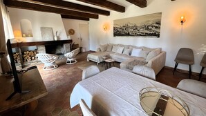 Un accogliente soggiorno con camino, divano e tavolo da pranzo.
