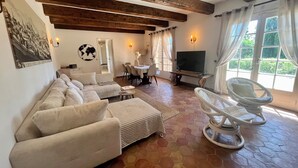 Un soggiorno con divano, tavolo da pranzo, televisore e una poltrona.