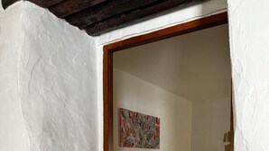 Een kamer met een bed, een schilderij aan de muur en een houten plafond.