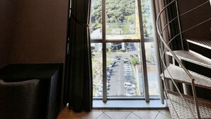 Una habitación con un gran ventanal, una escalera y un equipo de aire acondicionado.