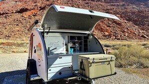 A camper with an open top, a storage box, and a sign indicating 'Red Base Rock Camp'. - Red Rock Base Camps Teardrop Trailer #3. Take your hotel room outside!  (Moab)