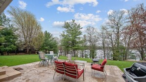A patio with outdoor furniture, a grill, and a view of trees and a body of water. - Soft Landings at the Hangar House! Next to the Clubhouse and Airstrip (Danbury)
