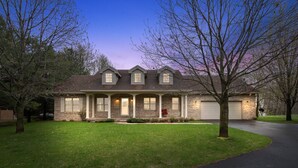 A two-story house with a front porch, a garage, and a well-maintained lawn. - Soft Landings at the Hangar House! Next to the Clubhouse and Airstrip (Danbury)
