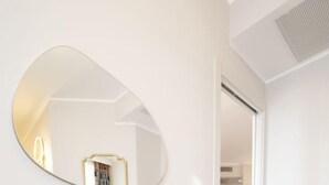 A modern room with a glass desk, a yellow chair, and a large mirror on the wall. - Residence Carl and Do three-room apartment Trilo Deluxe Mountain for 5 people (Baveno)