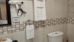 A bathroom with a hair dryer, a towel rack, and a toilet. - Beres Vale Apartments - King Room
 (Castara)
