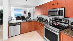 Una cocina moderna con electrodomésticos de acero inoxidable, armarios de madera y vistas al exterior.