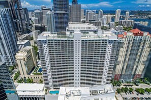 A high-rise hotel with a curved facade, multiple balconies, and a view of the surrounding cityscape. - Spacious 2 Bed Unit in Brickell with Free Parking (Miami)