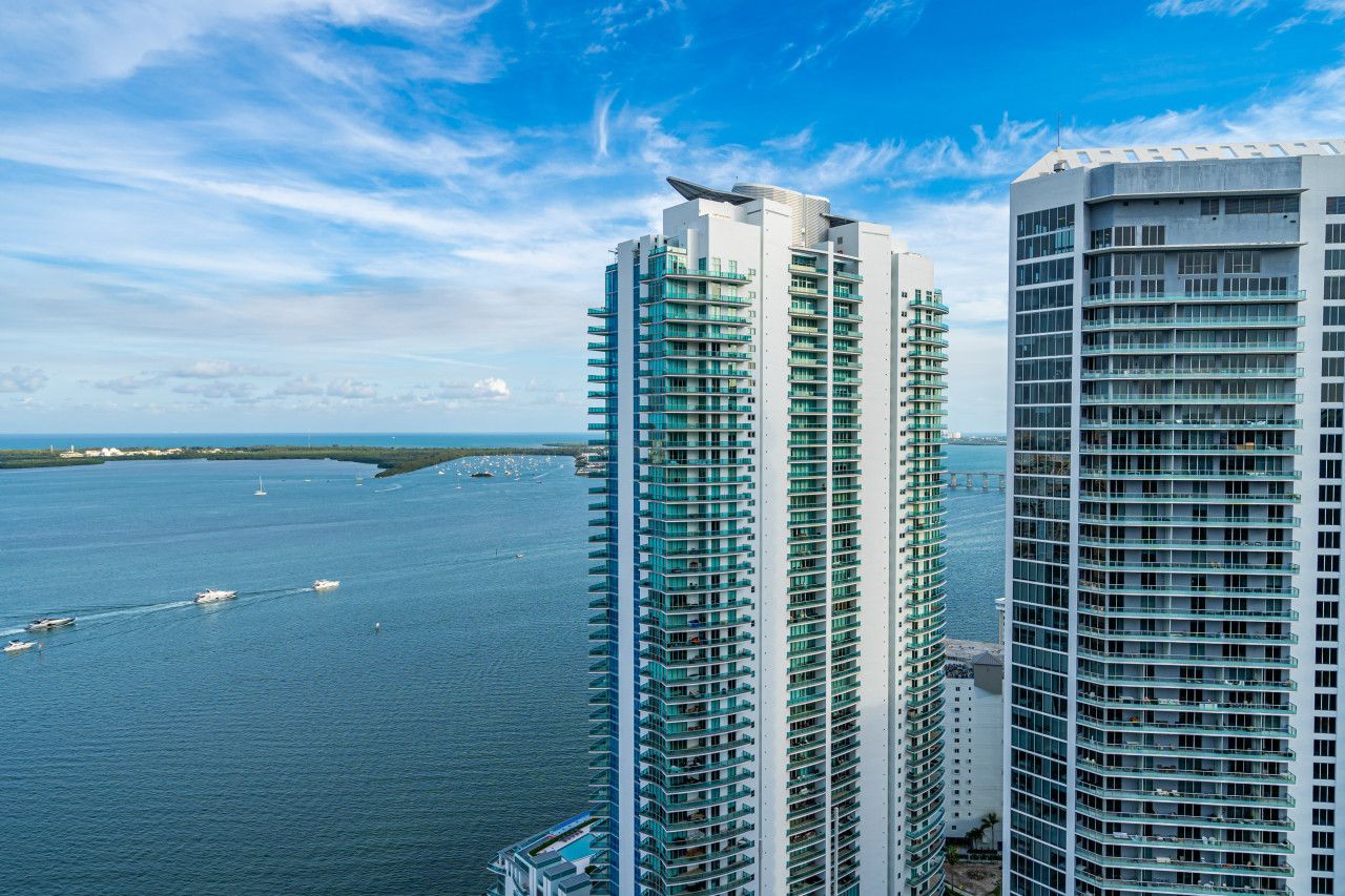 Deux immeubles de grande hauteur dotés de balcons donnant sur une étendue d’eau.