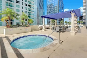 A rooftop pool area with a hot tub, seating, and a pergola. - Amazing 1 Bed in Brickell key W/ FREE PKG (Miami)