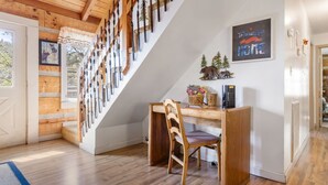 Eine Holztreppe mit weißer Wand und einem Schreibtisch mit Stuhl.