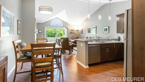 Une cuisine moderne avec des meubles en bois, un îlot central et des luminaires suspendus.