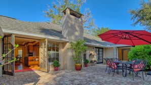 A patio with a brick floor, a red umbrella, and outdoor furniture. - 3/2 Ocala Home, Historic District and Town Sq. (Ocala)