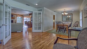 A spacious living area with hardwood flooring, a dining table with chairs, and a kitchen in the background. - 3/2 Ocala Home, Historic District and Town Sq. (Ocala)