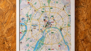 Mapa da cidade emoldurado, com estradas, pontos turísticos e um rio.